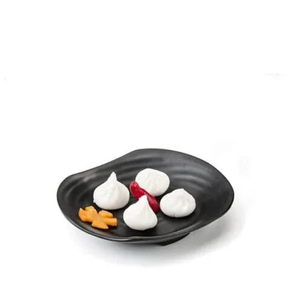 a black plate with white and red food on it