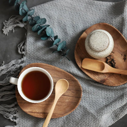 a cup of tea and spoon on a plate