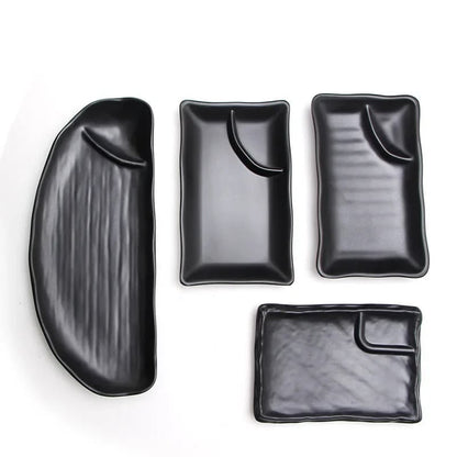 four black rectangular sushi trays with different shapes