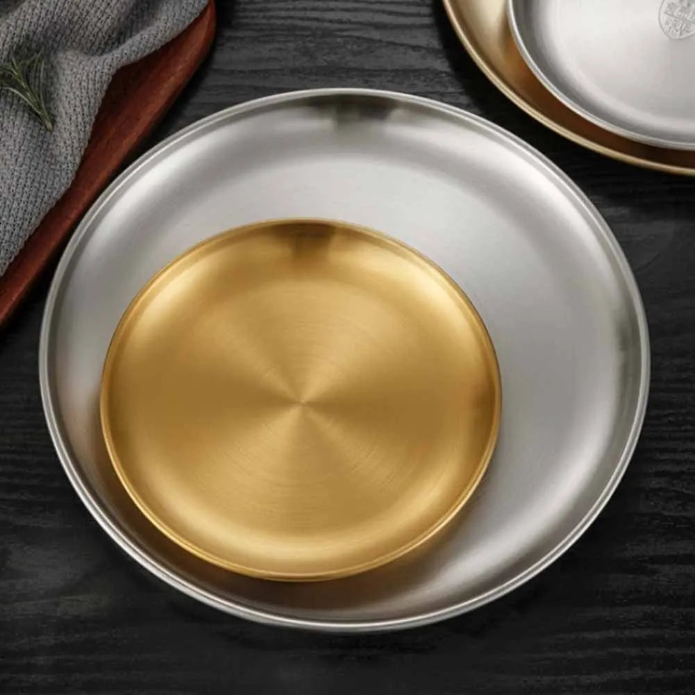 a gold and silver stainless steel round plates of different sizes