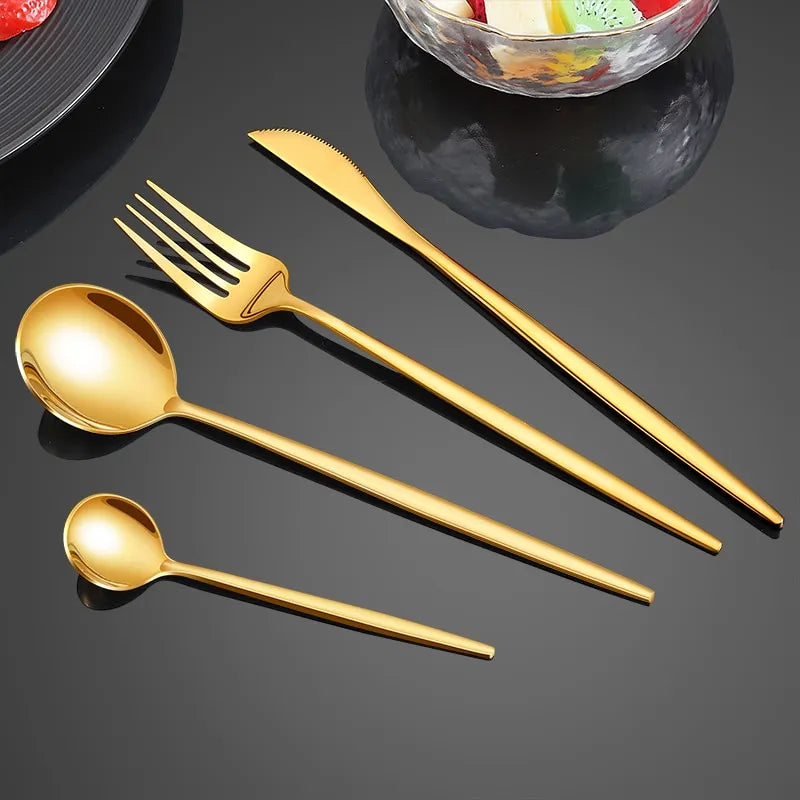 a gold spoon fork knife and a bowl of fruit