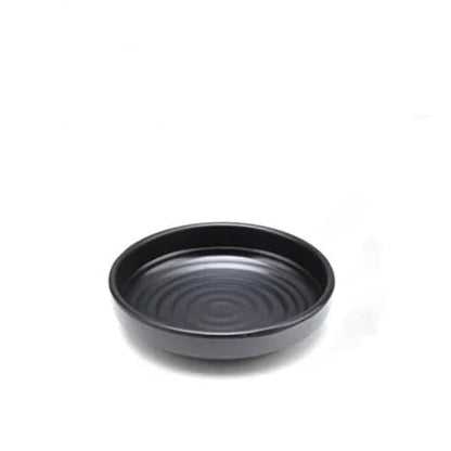 a large black bowl with spiral pattern a white background