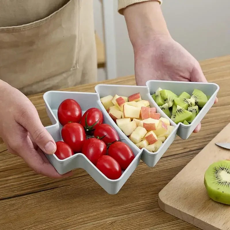 a person holding a christmas tree tray with fruits