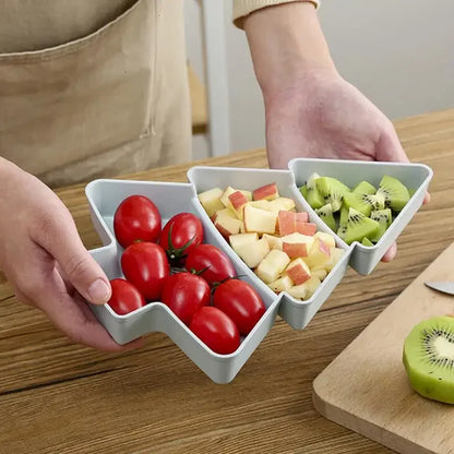 a person holding a christmas tree tray with fruits