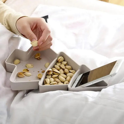 a person holding a phone and eating pistachios